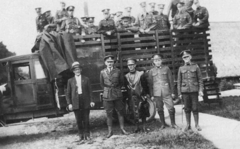 A restored military photo from world war 1 with men standing in a truck and around a truck