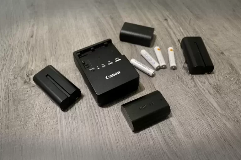 Canon camera batteries and a battery charger with some Eneloop batteries on the counter at First Choice Photo