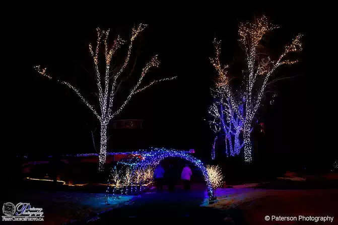 People walk through the Coaldale, Alberta Christmas light display at night