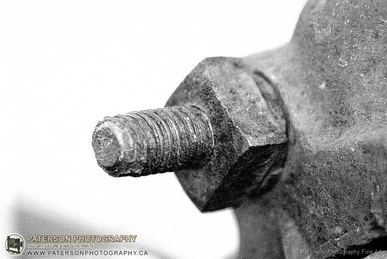 Black & white print of a rusted nut and bolt showing the texture of the metal