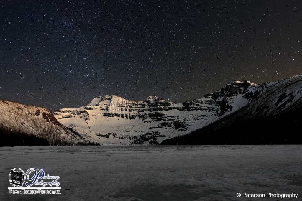 Waterton Lakes astro photography picture at Cameron Lake showing the frozen lake and mountains, locations for nature photography